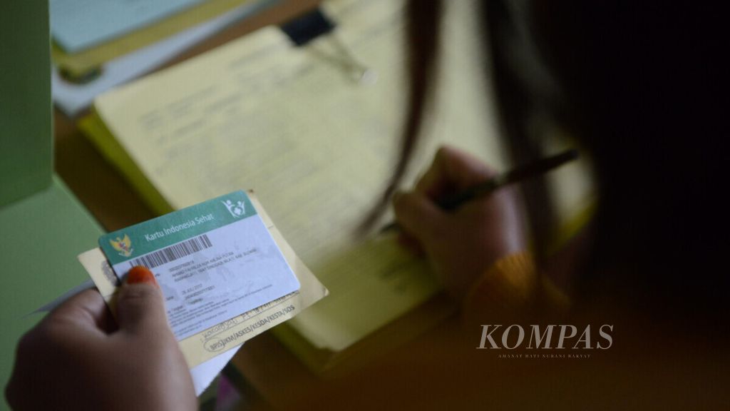 Warga peserta program Jaminan Kesehatan Nasional Kartu Indonesia Sehat mengisi formulir pendaftaran untuk mendapat layanan kesehatan di Puskesmas Tegalrejo, Yogyakarta, Jumat (26/7/2019).  