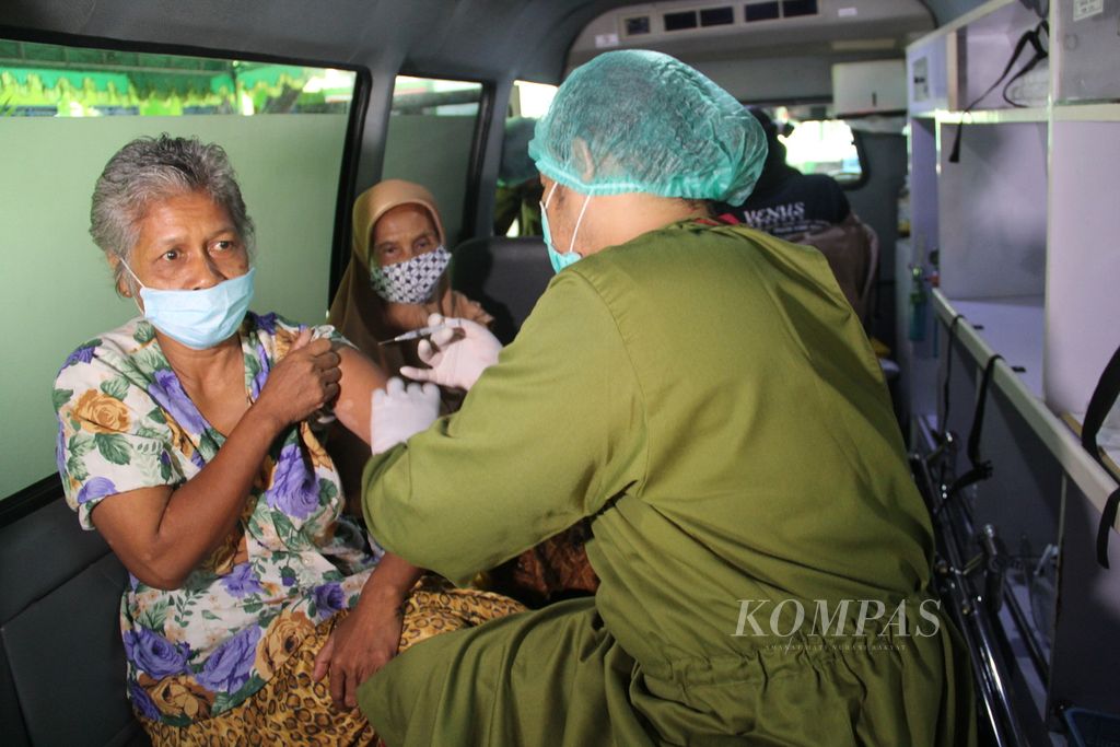 Warga lanjut usia menjalani vaksinasi Covid-19 di atas ambulans, Jumat (21/1/2022), di Desa Sumbermulyo, Kabupaten Bantul, DIY.
