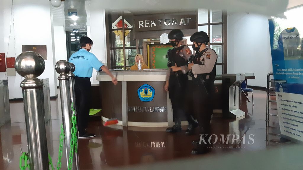 Aparat kepolisian berjaga di dalam Gedung Rektorat Unila selama penyidik KPK melakukan penggeledahan, Senin (22/8/2022).
