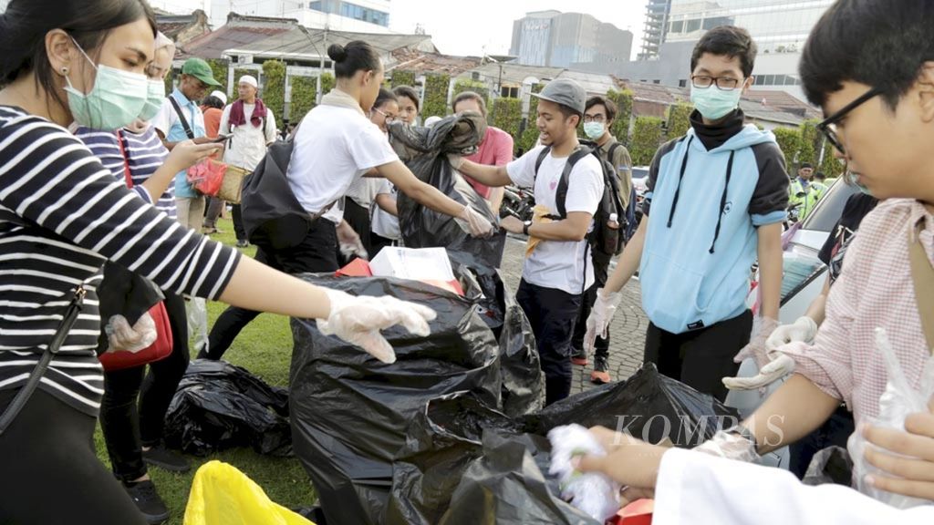Sejumlah sukarelawan anak-anak muda yang bersifat independen, atau tidak terkait dengan kelompok politik dan golongan apa pun, turun sore hari untuk membantu memungut sampah di kawasan Patung Pak Tani dan Balai Kota, Jakarta, awal November 2016.