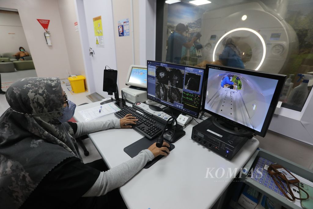 Anggota staf bagian radiologi Rumah Sakit Jantung Harapan Kita, Jakarta, mengoperasikan alat MRI (<i>magnetic resonance imaging</i>) untuk proses pemeriksaan pasien, Kamis (19/1/2023).  Kesehatan termasuk sektor yang masif menggunakan kemajuan teknologi informatika.