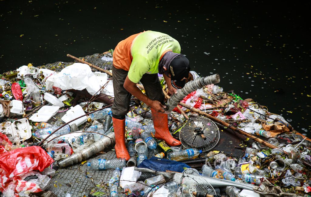Petugas Penanganan Prasarana dan Sarana Umum (PPSU) memilah sampah plastik yang dikumpulkan dari saluran air di Waduk Melati, Tanah Abang, Jakarta Pusat, Rabu (21/12/2022).