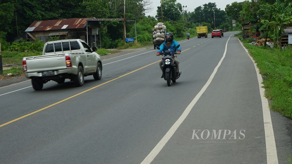 Kendaraan melintasi jalur lintas timur Sumatera yang menghubungkan Palembang dengan Kabupaten Ogan Ilir, Sumatera Selatan, Minggu (19/12/2021). Setelah tol Trans-Sumatera dibangun, lalu lintas di jalur lintas timur tidak seramai sebelum ada tol. Kemacetan tidak banyak terjadi.