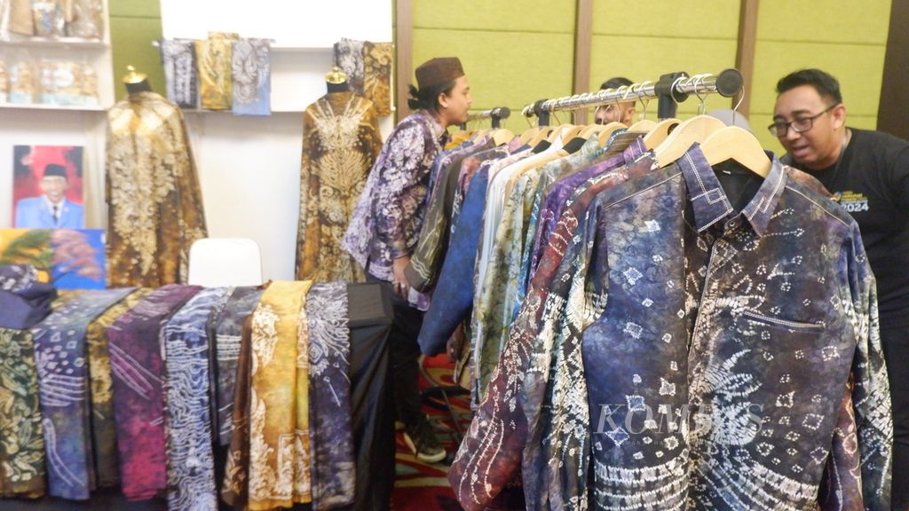 Pengunjung melihat produk kain dan busana sasirangan dalam acara Klinik Kekayaan Intelektual Bergerak (Mobile Intellectual Property Clinic) Kalimantan Selatan di Banjarmasin, Rabu (19/6/2024) malam. 