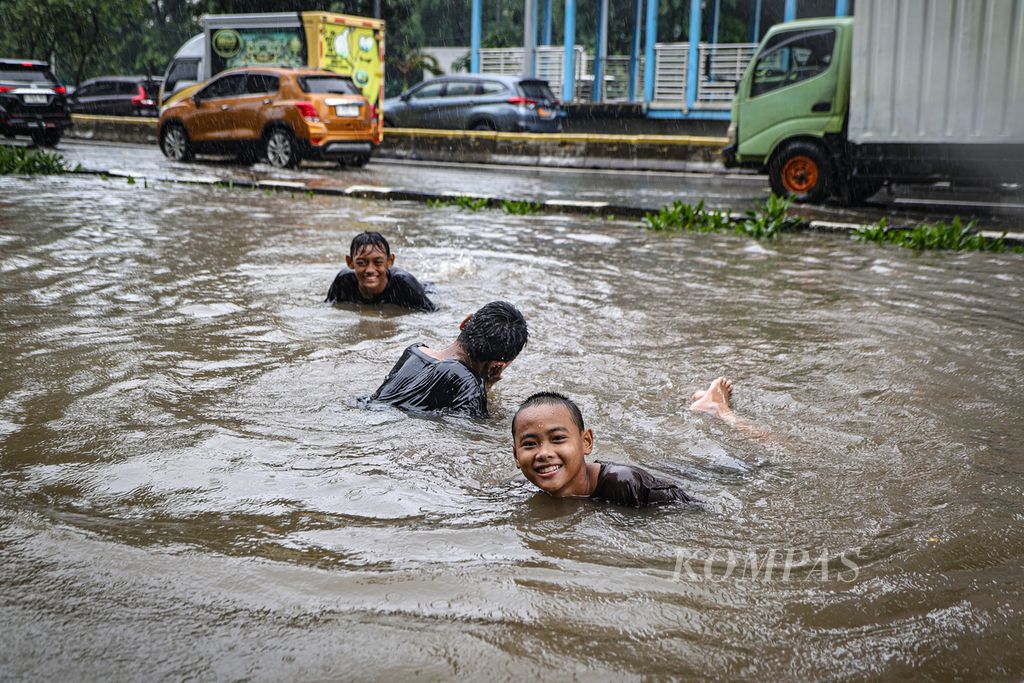 Anak-anak berenang di genangan air di kawasan Cempaka Putih, Jakarta Pusat, Kamis (29/2/2024).