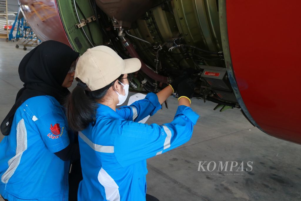 Deby Silvia dan Fara Julia, mekanik yang sedang memperbaiki pesawat milik Lion Group di Batam Aero Technic, Batam, Kepulauan Riau, Jumat (22/3/2024). Untuk bekerja sebagai mekanik, mereka harus memiliki lisensi dan latar belakang pendidikan penerbangan.  