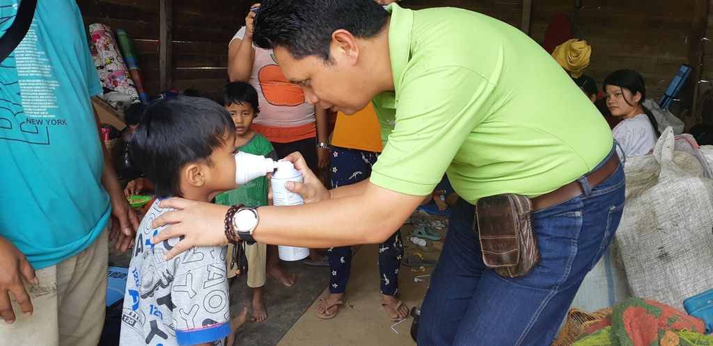 Seorang pengungsi di Desa Pematang Raman, Kecamatan Kumpeh, Kabupaten Muaro Jambi, Jambi, mencoba bantuan oksigen yang diberikan melalui Yayasan Dana Kemanusiaan Kompas, Sabtu (5/10/2019).  