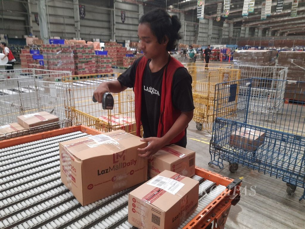 Seorang petugas memindai kode kardus berisi barang-barang pesanan konsumen di gudang logistik Lazada di Cimanggis, Depok, Jawa Barat, Selasa (12/9/2023). 