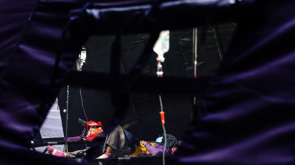 Seorang pasien yang dirawat sementara di tenda darurat perawatan di halaman Rumah Sakit Umum Daerah Cibinong, Cibinong, Kota Bogor, Jawa Barat, karena ruang rawat dan IGD penuh, Kamis (24/6/2021). 