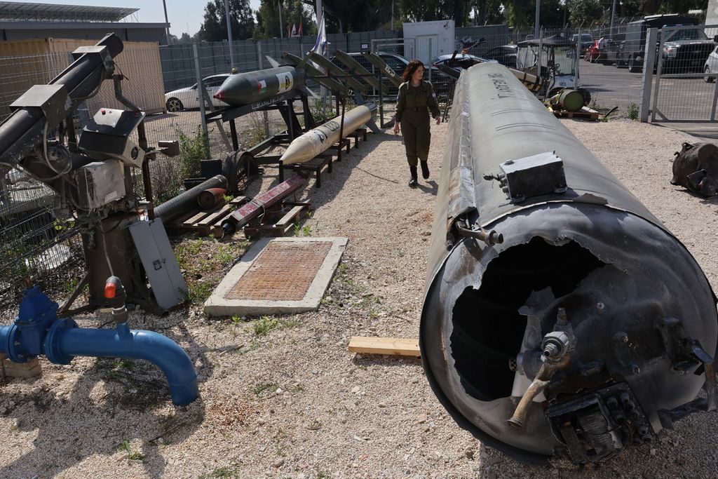 Seorang anggota militer Israel berjalan di dekat rudal balistik Iran yang jatuh di Israel di pangkalan militer Julis dekat kota Kiryat Malachi, Israel, Selasa (16/4/2024). 
