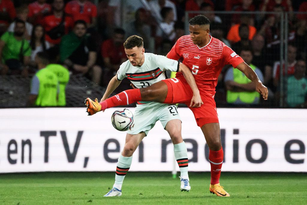 Penyerang Portugal Diogo Jota (kiri) mengontrol bola yang berusaha direbut bek Swiss Manuel Akanji dalam Liga Nasional Eropa grup A2 di Stadion Stade de Geneve, Jenewa, Swiss, Senin (13/6/2022) dini hari WIB. Portugal kalah 0-1 dari Swiss. 