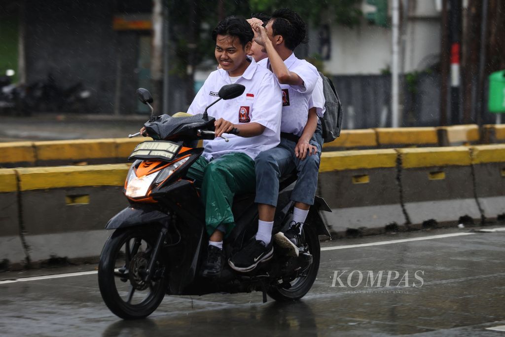 Tiga siswa menaiki motor tanpa mengenakan helm di Jalan Jatinegara Barat, Jakarta, Senin (4/3/2024). Kepolisian Republik Indonesia mulai menggelar Operasi Keselamatan Lalu Lintas 2024 mulai dari 4 sampai 17 Maret 2024.
