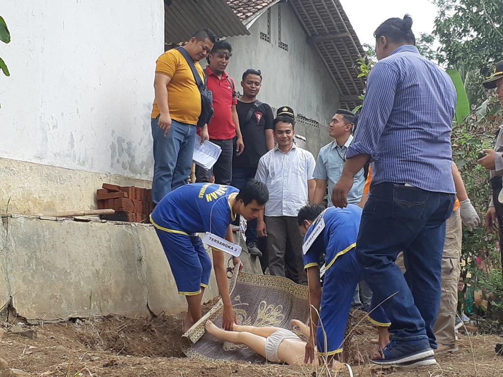 Para tersangka kasus pembunuhan melakukan rekonstruksi membawa jenazah saudaranya untuk dikubur di pekarangan belakang rumah, Rabu (28/8/2019), di Desa Pasinggangan, Banyumas, Jawa Tengah.