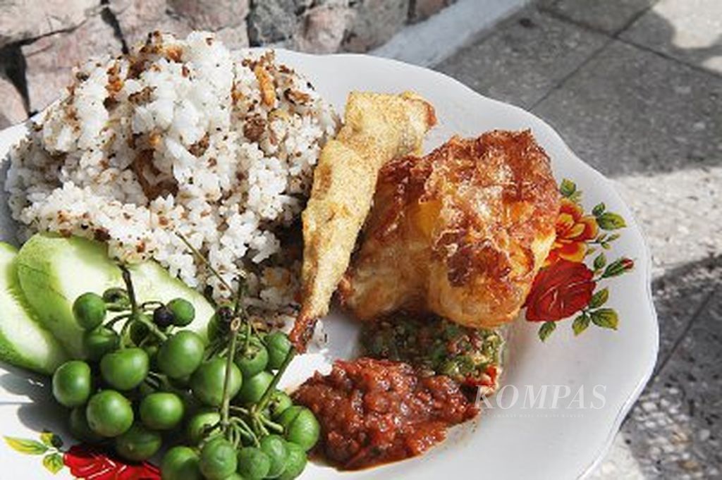Nasi tutug oncom dengan aneka lalapan, sambal goang, dan lauk yang disebut ”selingkuhan” di Warung Nasi Tutug Oncom Kalektoran Tasikmalaya, Jawa Barat,