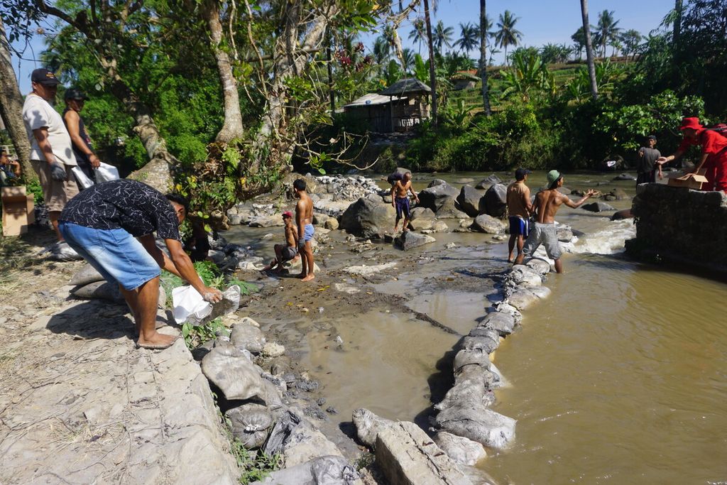Warga dan tim SAR gabungan membendung Sungai Tajur di sekitar tambang emas ilegal Desa Pancurendang, Kecamatan Ajibarang, Kabupaten Banyumas, Jawa Tengah, Jumat (28/7/2023).