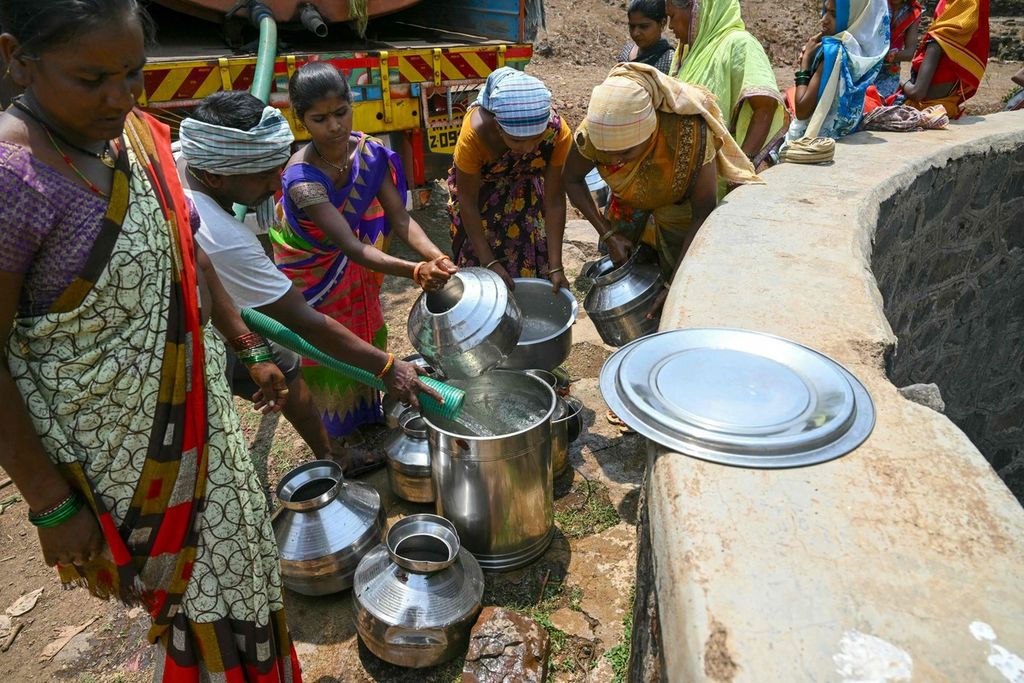 Warga Desa di Shahapur, Negara Bagian Maharashtra, India, mengisi tempayan dengan air dari tangki air di saat negara itu dilanda gelombang panas, 24 Mei 2024.