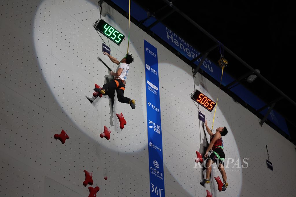 Pemanjat Indonesia, Veddriq Leonardo (kiri) bertanding melawan atlet tuan rumah China, Wu Peng dalam final nomor perlombaan perseorangan kecepatan alias speed panjat tebing Asian Games Hangzhou 2022 di Shaoxing Keqiao Yangshan Sport Climbing Centre, Provinsi Zhejiang, China, Selasa (3/10/2023). 