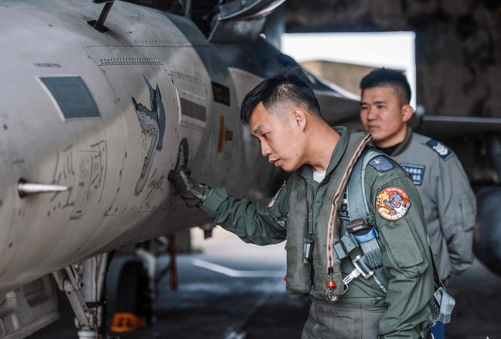 Foto yang dirilis oleh Kementerian Pertahanan Nasional per 9 April 2023 ini menunjukkan pilot pesawat tempur Taiwan disamping F-CK-1 di Taiwan. 