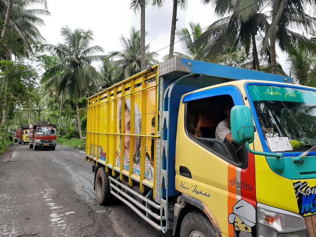 Truk-truk pengangkut pasir dan batu dari Gunung Merapi masih ramai melintasi jalan di Desa Kemiren, Kecamatan Srumbung, Kabupaten Magelang, Jawa Tengah, Kamis (10/3/2022).