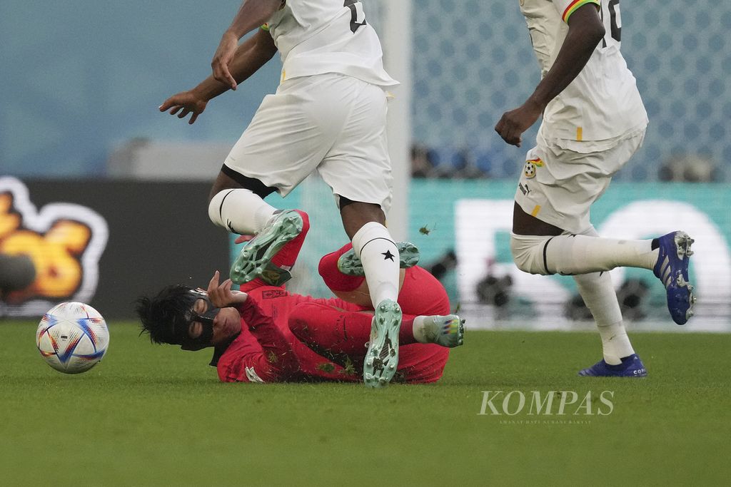 Pemain Korea Selatan Son Heungmin terjatuh setelah berebut bola dengan pemain Ghana saat bertanding di fase Grup H Piala Dunia 2022 di Stadion Education City, Qatar, Senin (28/11/2022). 