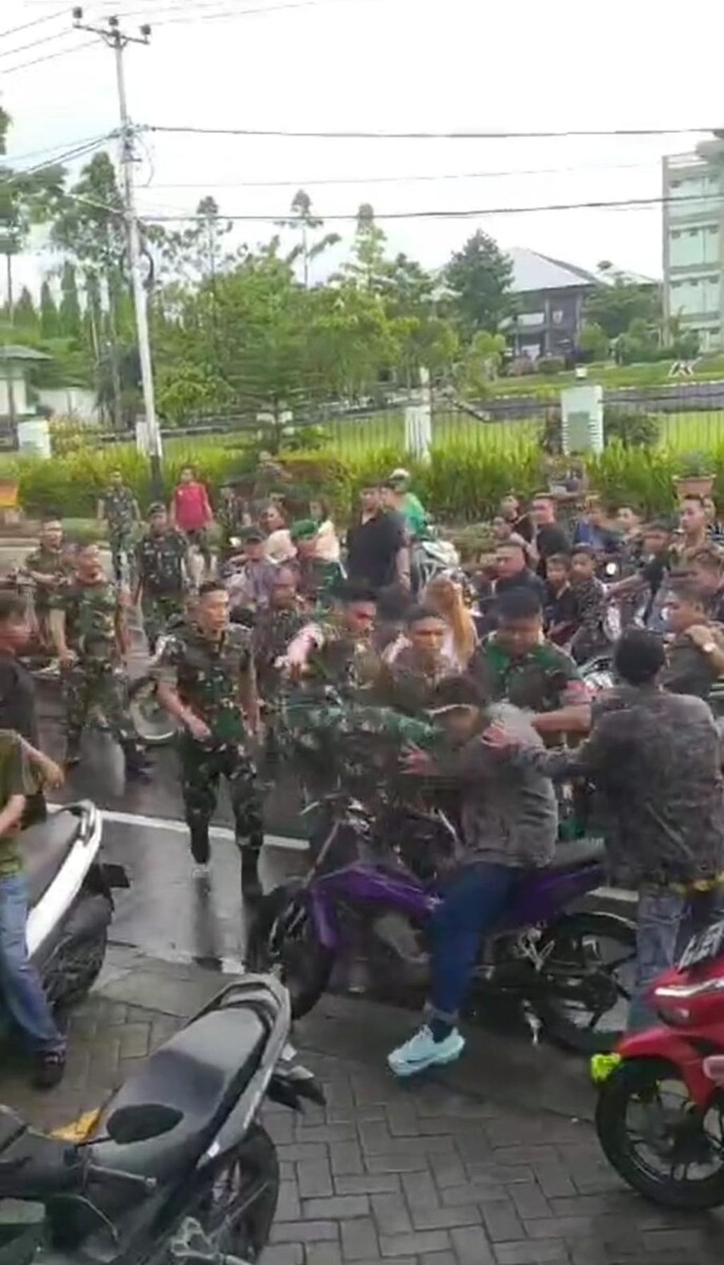 Tangkapan layar kekerasan yang diduga dilakukan oleh anggota TNI terhadap warga pengantar jenazah yang mengendarai sepeda motor di Manado, Sulawesi Utara, Jumat (5/1/2024). 