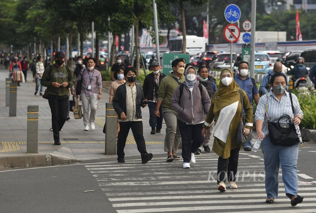 Pekerja berjalan kaki di jalur pedestrian Jalan Sudirman, Jakarta, pada jam pulang kerja, Selasa (23/8/2022). 