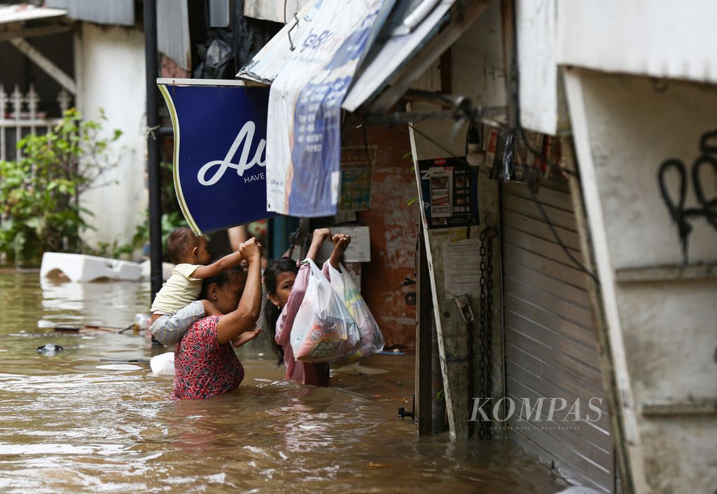 Warga menembus banjir akibat meluapnya Kali Krukut di Kelurahan Karet Tengsin, Tanah Abang, Jakarta Pusat, Selasa (25/2/2020). Banjir akibat curah hujan yang tinggi ini tidak hanya merendam kawasan permukiman, tetapi juga memutus akses jalan di sejumlah wilayah di Jakarta, Bekasi, dan Tangerang.