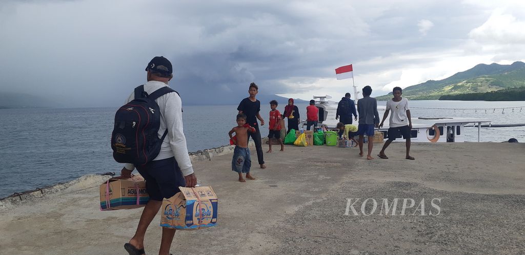 Penumpang yang baru saja turun dari KM Sabuk Nusantara 108 melanjutkan perjalanan dengan perahu motor dari Pelabuhan Menanga, Pulau Solor, Kabupaten Flores Timur, Nusa Tenggara Timur, pada Selasa (1/11/2022). Mereka akan berlayar ke Pulau Adonara di seberang Pulau Solor.
