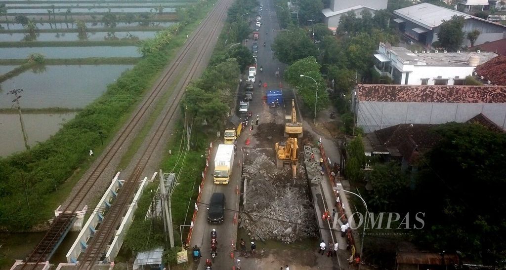 Antrean kendaraan dari arah Tuban melintasi sisa jalan dari Jembatan Ngaglik 1 yang ambles dan sedang dalam proses penghancuran di Kabupaten Lamongan, Jawa Timur, Rabu (30/3/2022).