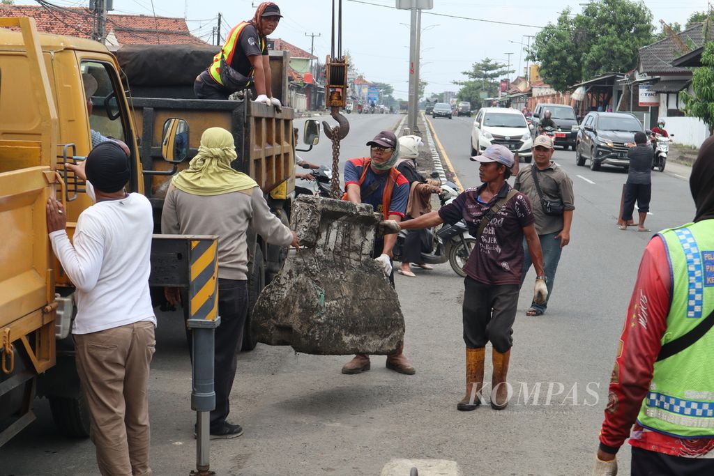 Petugas menutup penggalan jalan atau U-turn dengan barrier beton menjelang Pasar Tegalgubug, Kabupaten Cirebon, Jawa Barat (18/4/2022). Pemasangan tersebut untuk mencegah kemacetan di sekitar pasar saat arus mudik Lebaran 2022.