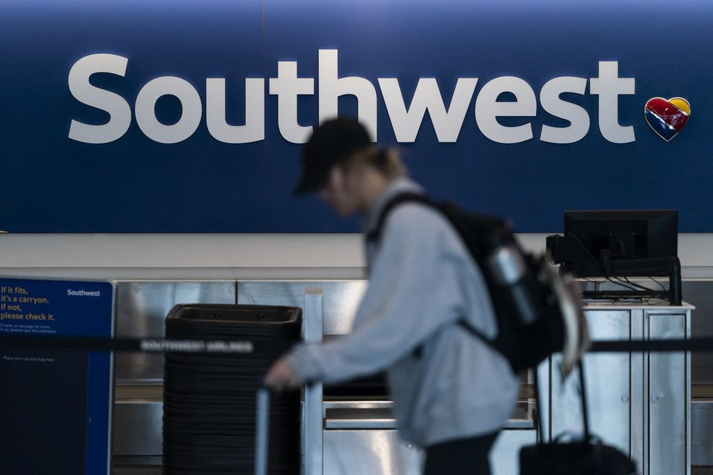 Seorang penumpang melewati konser tiket Southwest Airlines di Bandara Internasional Los Angeles di Los Angeles, AS, pada 18 April 2023. 