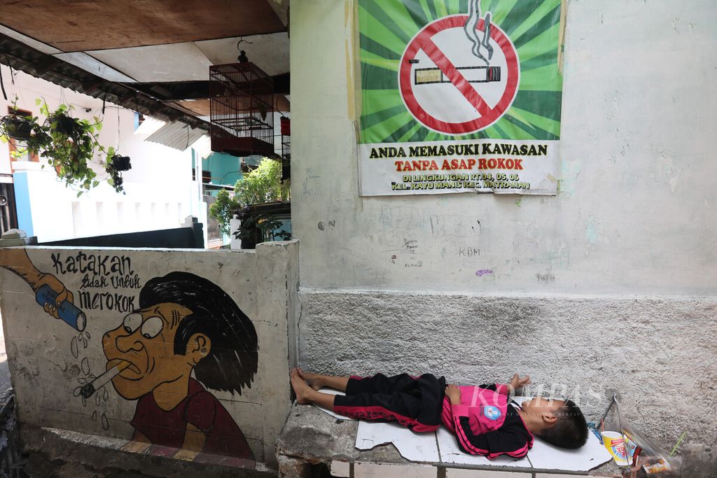 Poster dan mural bertema kawasan bebas asap rokok menghiasi permukiman warga di lingkungan RW 006 Kelurahan Kayu Manis, Matraman, Jakarta Timur, Selasa (14/11/2023).