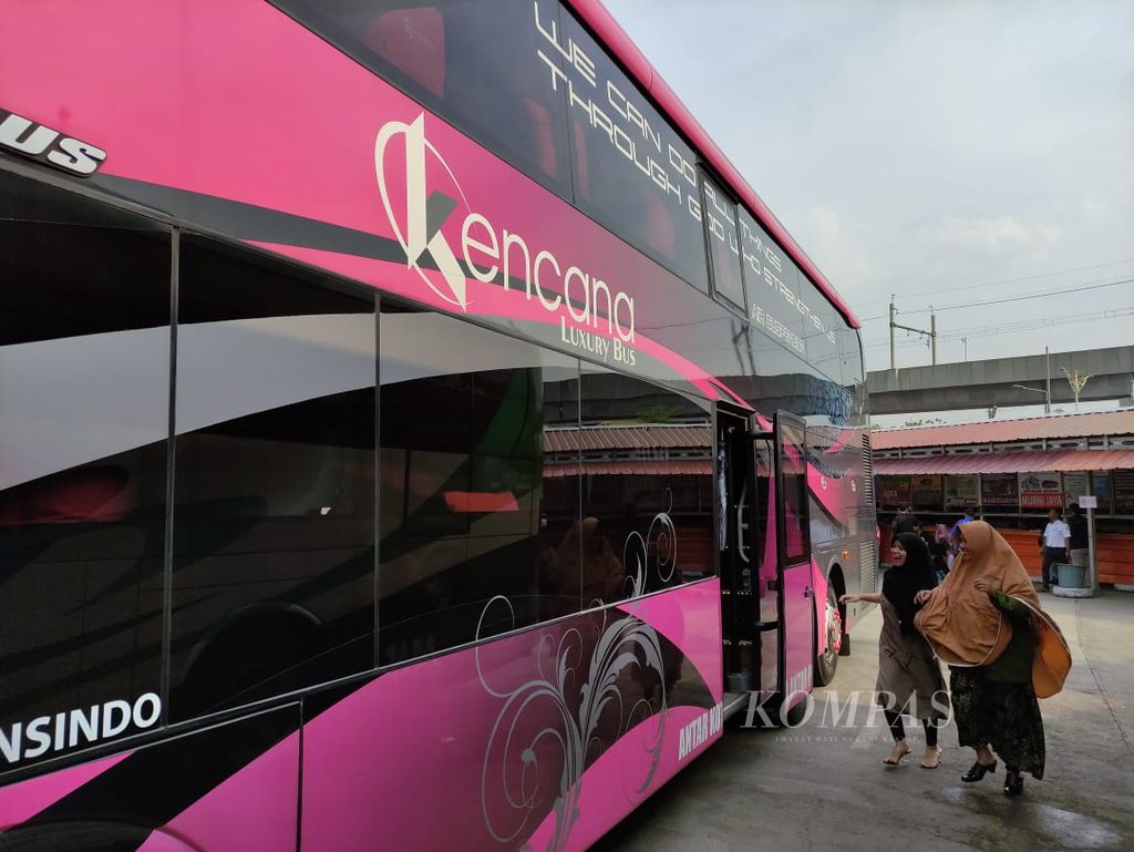 Beberapa penumpang bergegas menuju bus Kencana menjelang keberangkatan dari Jakarta, Jumat (15/12/2023).