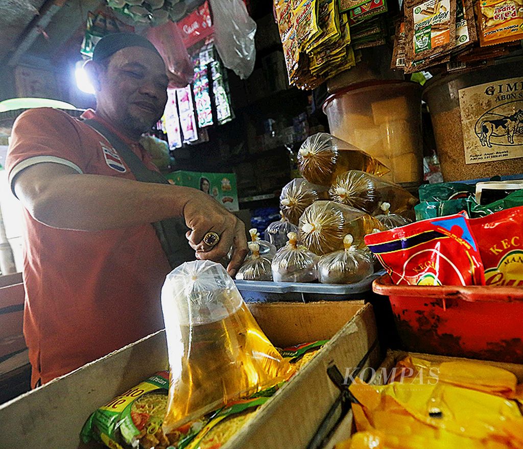 Rauf, pedagang bahan pokok di Pasar Kebayoran Lama, Jakarta Selatan, Senin (24/1/2022), menunjukkan stok minyak gorengnya yang tak kunjung terjual sejak pemerintah menyubsidi harga minyak goreng kepada konsumen melalui ritel modern. 