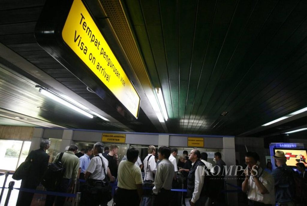 Warga negara asing antre untuk membayar visa saat kedatangan (<i>visa on arrival</i>) di loket BNI di Bandara Internasional Soekarno-Hatta, Jakarta, Senin (20/10/2008).