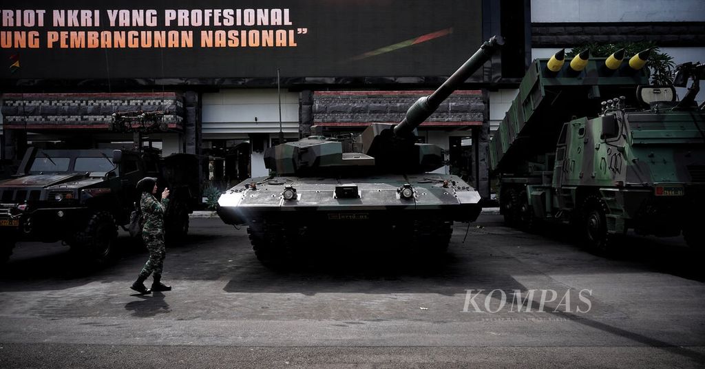 Seorang anggota Korps Wanita Angkatan Darat melintasi tank Leopard yang menjadi bagian dari alutsista TNI AD saat diparkir di depan gedung tempat Rapat Pimpinan TNI AD Tahun Anggaran 2023 di Markas Besar TNI AD, Jakarta, Jumat (10/2/2023). 