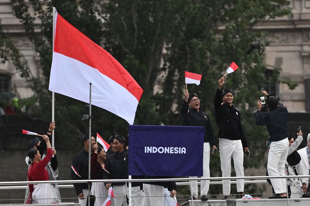 Kontingan Indonesia mengikuti defile dengan menaiki kapal menyusuri sungai Seine saat pembukaan Olimpiade Paris 2024 di Paris, Perancis, Kamis (26/7/2024). Sebanyak 205 kontingen dari negara peserta mengikuti defile pembukaan Olimpiade Paris 2024 dengan menggunakan 85 kapal menyusuri Sungai Seine sejauh 6 km dari Jembatan Austerlitz menuju Trocadero, dekat Menara Eiffel.