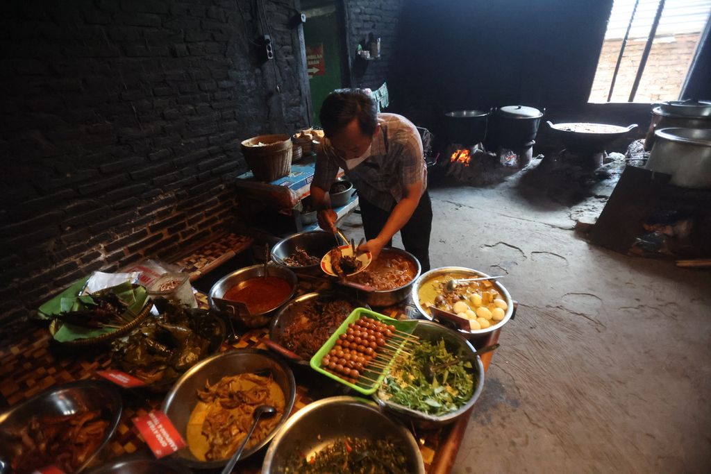 Pengunjung mengambil makanan mangut lele di rumah makan Mangut Lele Dapur Asli Mbok Marto Ijoyo, Kecamatan Sewon, Kabupaten Bantul, Daerah Istimewa Yogyakarta, Rabu (21/9/2022). 