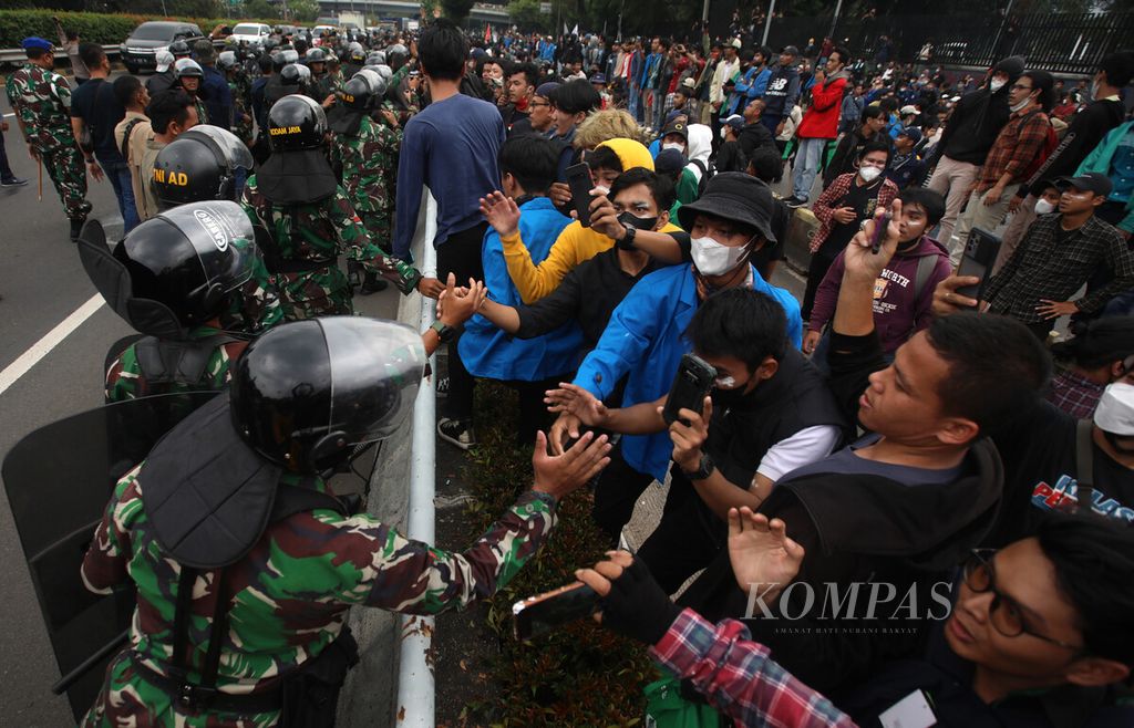 Members of the TNI are greeted by students shaking hands in front of the Parliament Building Complex, Senayan, Jakarta, Monday (11/4/2022).