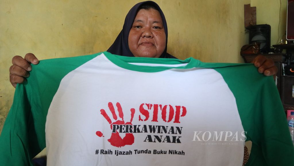 Lili Marlina (34) menunjukkan baju bertuliskan &quot;Stop Perkawinan Anak&quot; di rumahnya di Desa Krasak, Kecamatan Jatibarang, Kabupaten Indramayu, Jawa Barat, Selasa (31/1/2023). Lili pernah menikah di usia 17 tahun dan hanya bertahan tiga bulan.