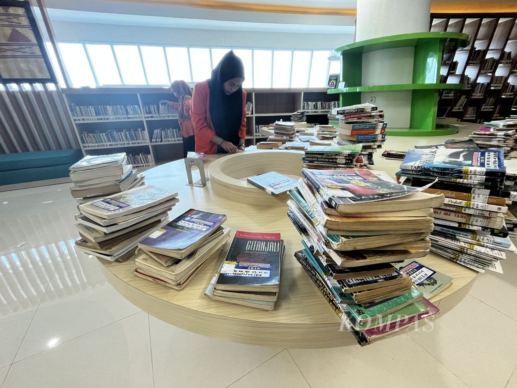 Petugas perpustakaan modern milik Pemerintah Provinsi Sulawesi Tenggara menata koleksi buku seperti terlihat pada Selasa (17/1/2023). Dibangun dengan anggaran lebih dari Rp 100 miliar, perpustakaan ini belum memiliki koleksi yang mutakhir, dan masih sepi dari pengunjung.