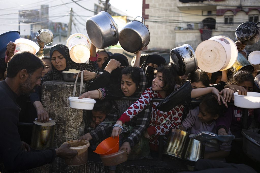 Anak-anak Palestina berebut untuk mendapatkan jatah makanan di salah satu pusat pembagian makanan di Rafah, Jalur Gaza, Selasa (12/3/2024).