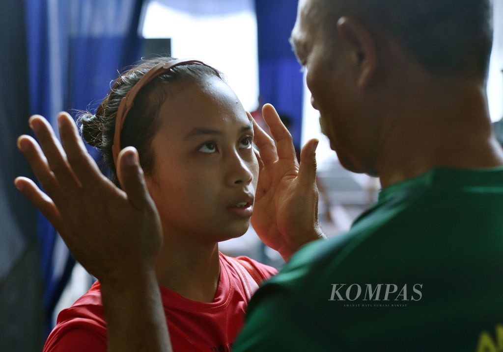 Lifter putri Jawa Timur, Luluk Diana Tri Wijayana, didoakan oleh pelatihnya di sela laga kelas 49 kg putri Kejuaraan Nasional Senior Angkat Besi 2022 di Sentul, Bogor, Jawa Barat, Selasa (25/10/2022). Luluk akhirnya berhasil meraih tiga emas dari kelas tersebut. 