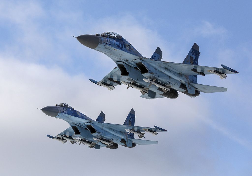 Pesawat jet tempur Su-27 milik Rusia terbang di atas pangkalan militer di wilayah Zhytomyr, Ukraina, pada 6 Desember 2018. 
