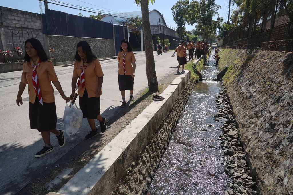 Pelajar SMK Pangudi Luhur Muntilan yang menjadi anggota Pramuka tingkat Bantara membersihkan sungai di dekat sekolah mereka di Kecamatan Muntilan, Kabupaten Magelang, Jawa Tengah, Kamis (27/7/2023). 