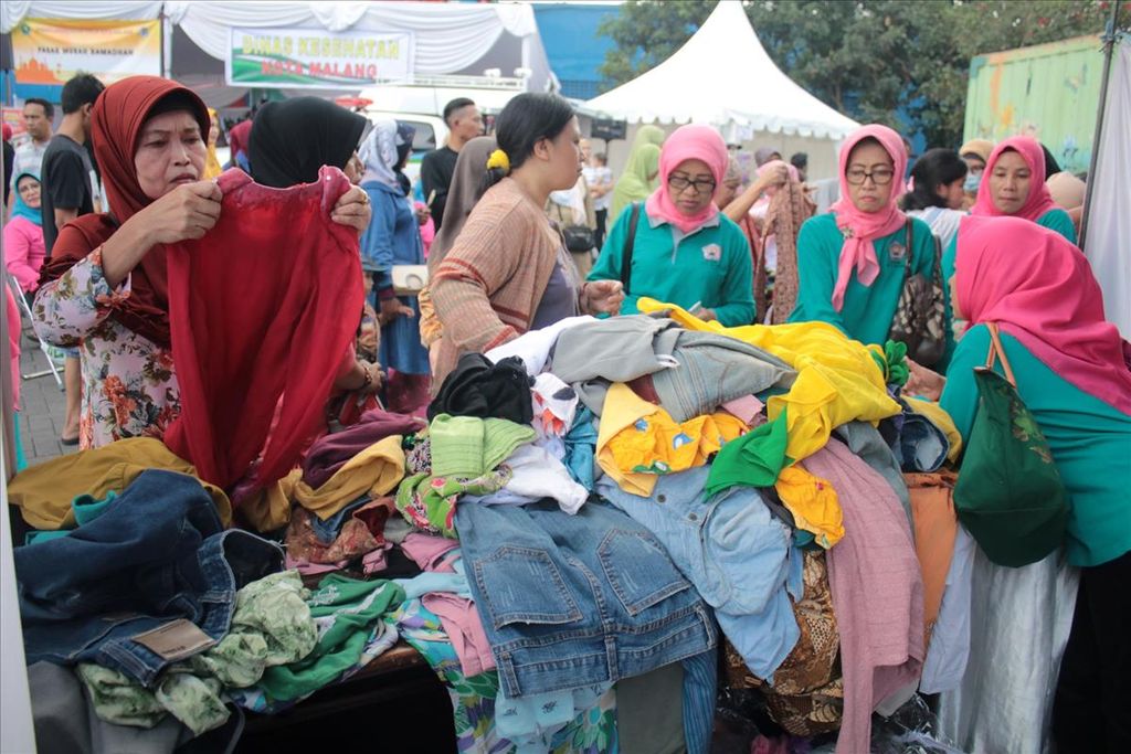 Masyarakat menyerbu stan penjualan baju bekas di Pasar Murah Ramadhan Kota Malang, Senin (27/5/2019), di lapangan luar Stadion Gajayana, Malang. 