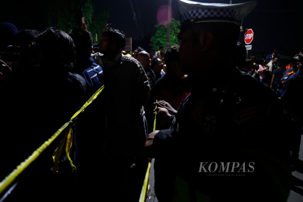 Polisi menjaga lokasi kecelakaan sebuah truk yang tertabrak kereta api di pelintasan sebidang Madukoro Raya, Kota Semarang, Jawa Tengah, Selasa (18/7/2023).