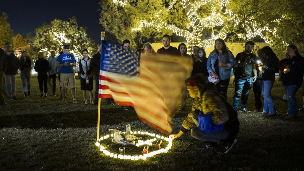 Warga berkumpul untuk memberikan penghormatan kepada korban penembakan di Thousand Oaks, California, AS, Kamis (8/11/2018). Penembakan yang dilakukan oleh veteran perang Korps Marinir AS berusia 28 tahun, Ian David Long, itu menewaskan 12 orang pengunjung bar.