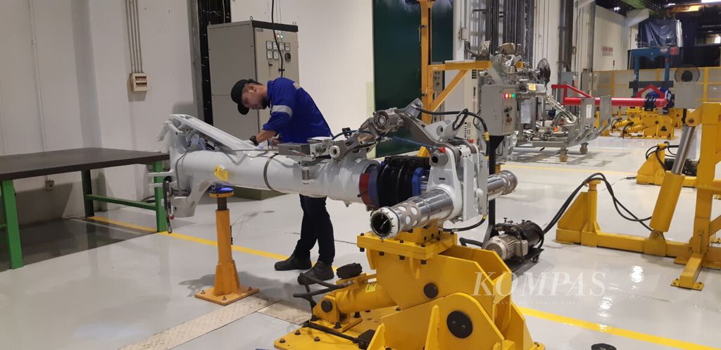 Seorang pekerja di bengkel roda pendaratan pesawat PT Garuda Maintenance Facility Aero Asia Tbk melakukan perawatan roda pendaratan, Kamis (11/10/2018).