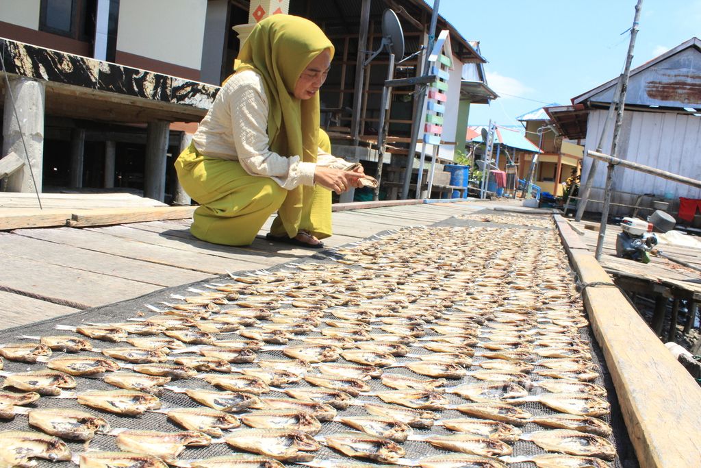 Rahmawati Dafrullah (51), Penjabat Kepala Desa Kaki Air, menunjukkan ikan kering yang dijemur di Desa Kaki Air, Kecamatan Teluk Kayeli, Kabupaten Buru, Maluku, Rabu (6/9/2023). Desa dengan jumlah penduduk sekitar 700 orang itu merupakan salah satu sentra perikanan di Buru.